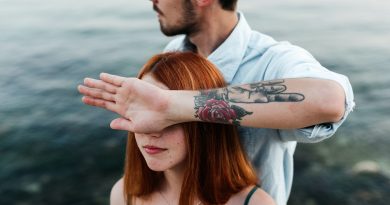 man in white dress shirt with tattoo on womans left cheek